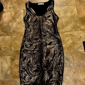 A mini black dress with gold sparkles. Size small and made by Bisou Bisou